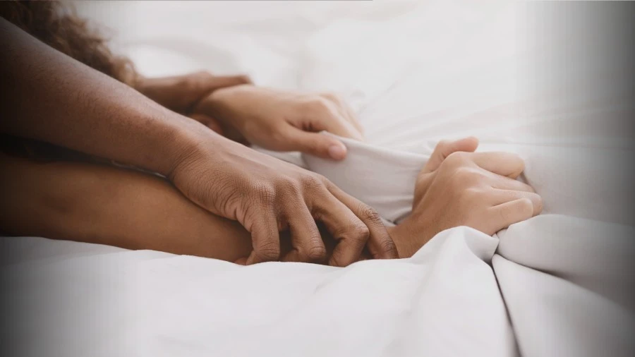 Photo of man's hands pinning down his girlfriend's arms