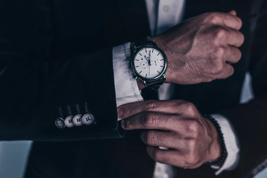 Close up of man's hands adjusting his shirt and watch