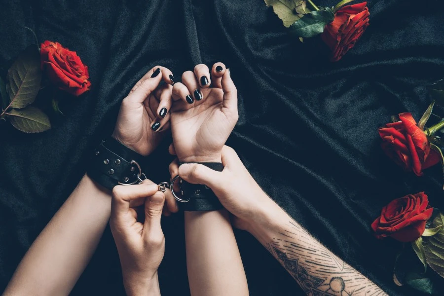 Man's hands putting on cuffs on woman's hands